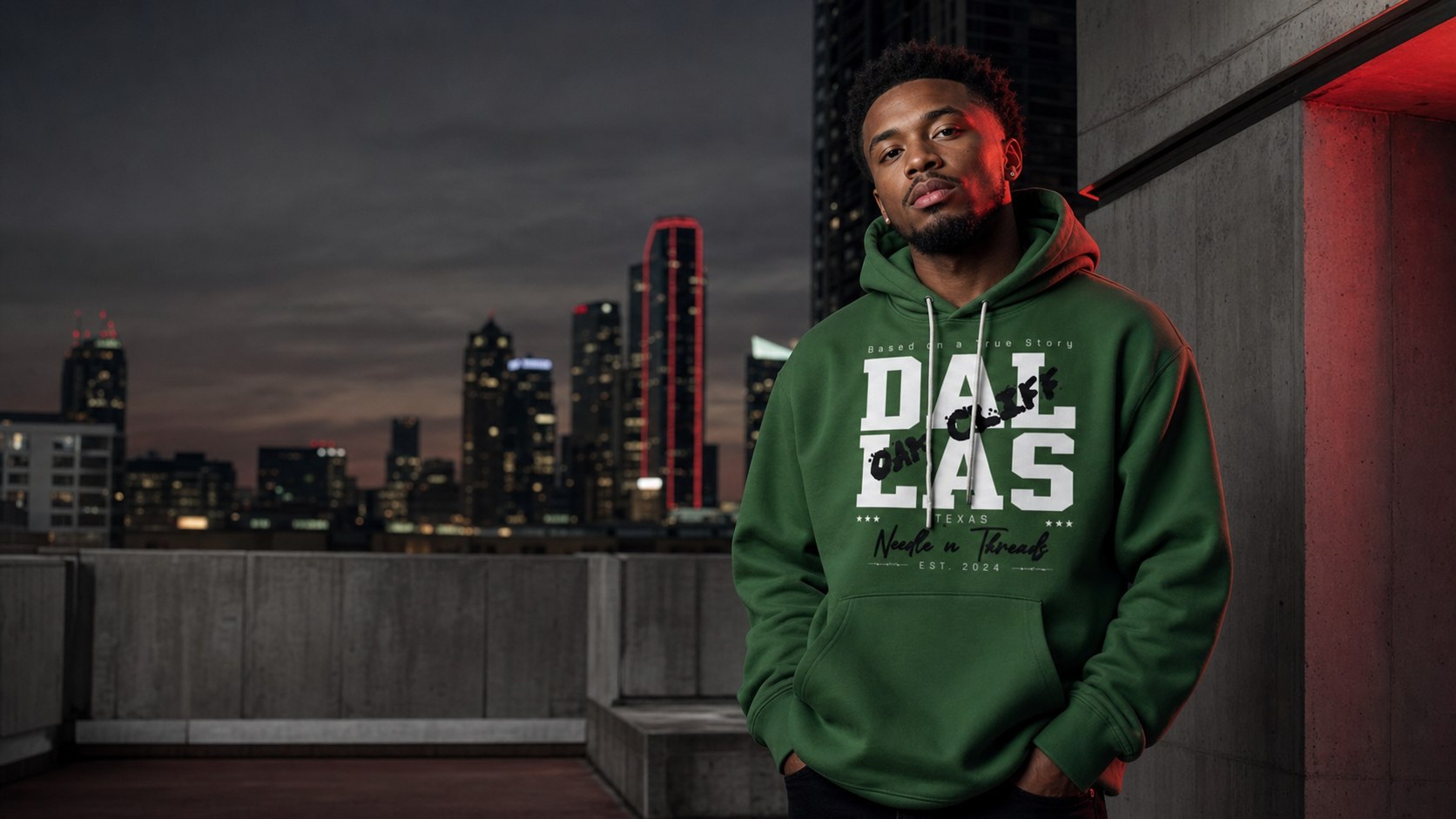 Black model wearing the green Needle N Threads Dallas hoodie on a Dallas rooftop